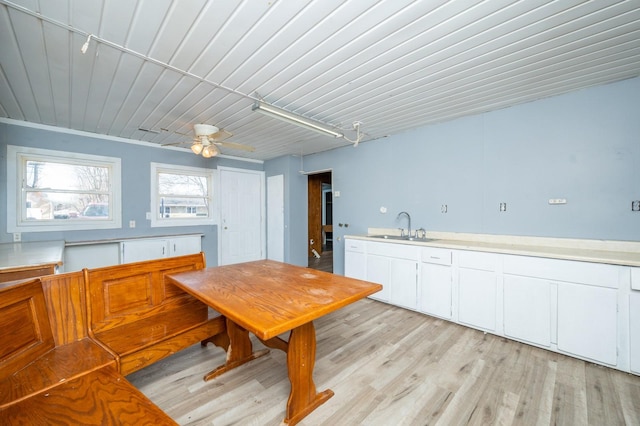 kitchen with ceiling fan, sink, white cabinets, and light hardwood / wood-style floors