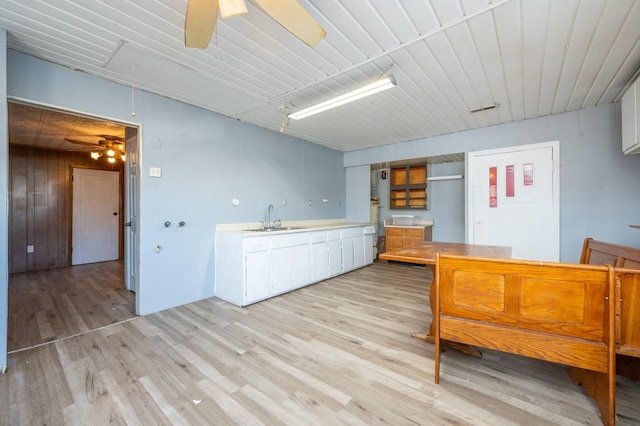 kitchen featuring light wood-type flooring, ceiling fan, sink, and white cabinets