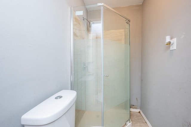 bathroom with a shower with door and toilet