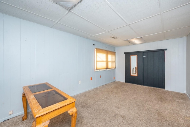 carpeted spare room featuring a paneled ceiling