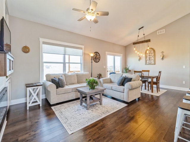 living room with lofted ceiling, dark hardwood / wood-style floors, and ceiling fan with notable chandelier