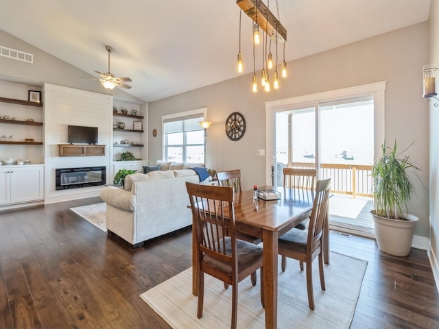 1837 15th Ave SE, Altoona, IA 50009 - dining room with lofted ceiling, dark wood-type flooring, a ceiling fan, a glass covered fireplace, and built in shelves