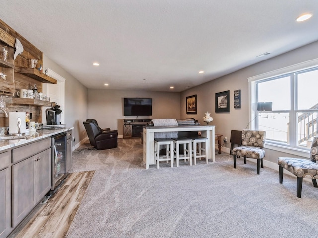 carpeted living room with beverage cooler and indoor wet bar