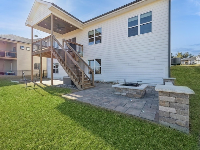 back of house with a yard, a fire pit, a patio, and ceiling fan