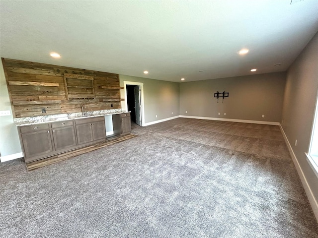 1837 15th Ave SE, Altoona, IA 50009 - unfurnished living room with carpet floors, baseboards, recessed lighting, and bar