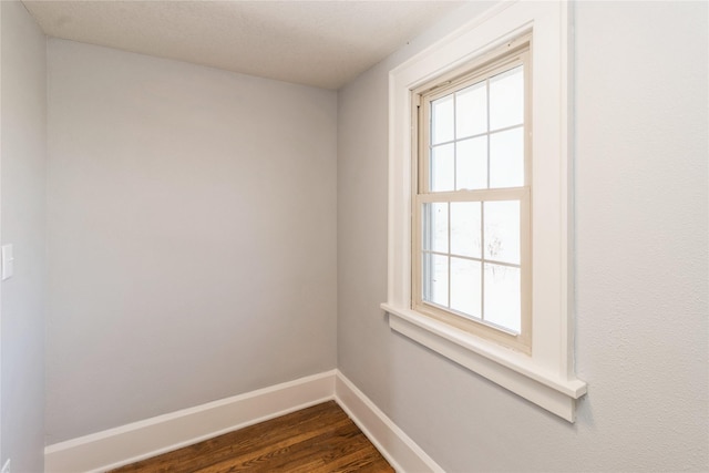 unfurnished room with dark wood-type flooring and a healthy amount of sunlight