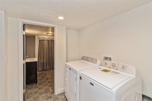 laundry area with separate washer and dryer and a textured ceiling