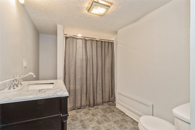 bathroom with vanity, a textured ceiling, and toilet