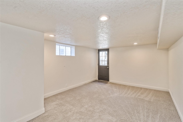 basement with light colored carpet and a textured ceiling