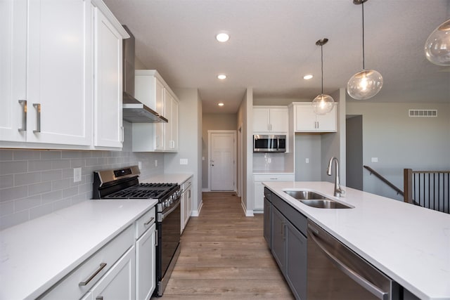 kitchen with stainless steel appliances, white cabinetry, and sink