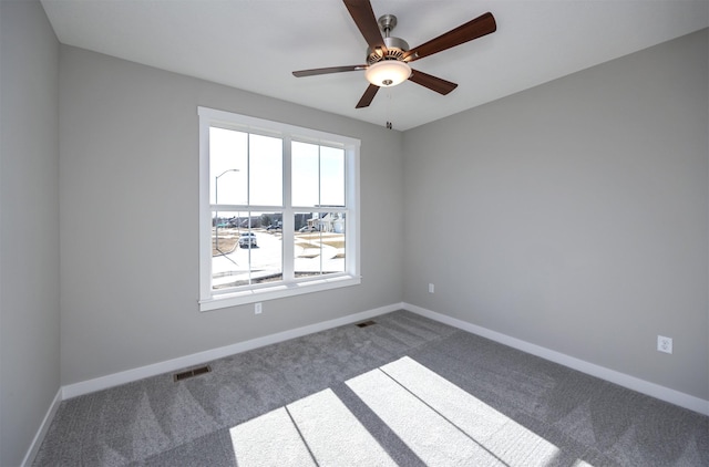 carpeted spare room with ceiling fan