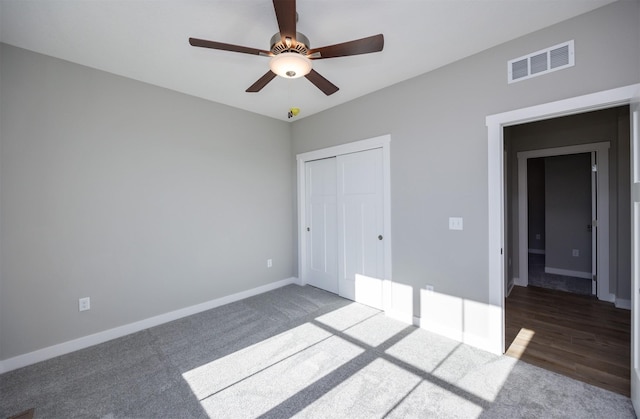 unfurnished bedroom featuring a closet, ceiling fan, and dark colored carpet