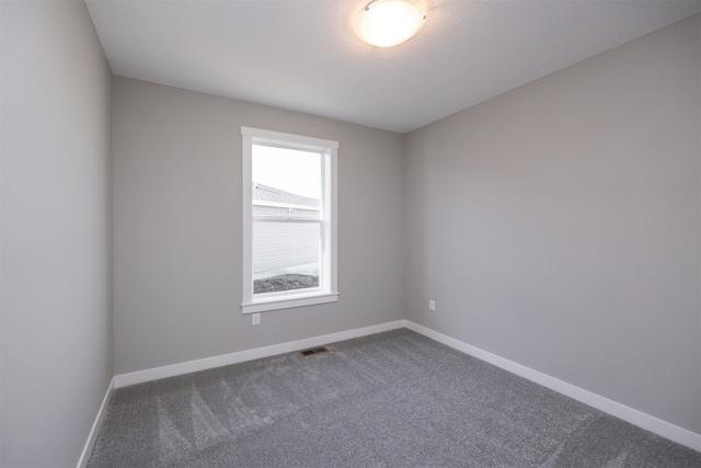 unfurnished room with dark carpet