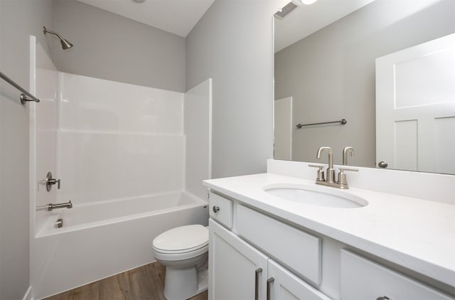 full bathroom with bathing tub / shower combination, hardwood / wood-style floors, vanity, and toilet