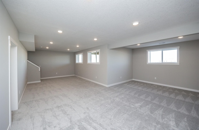 basement with light carpet and a textured ceiling