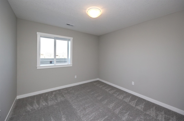 carpeted empty room with a textured ceiling