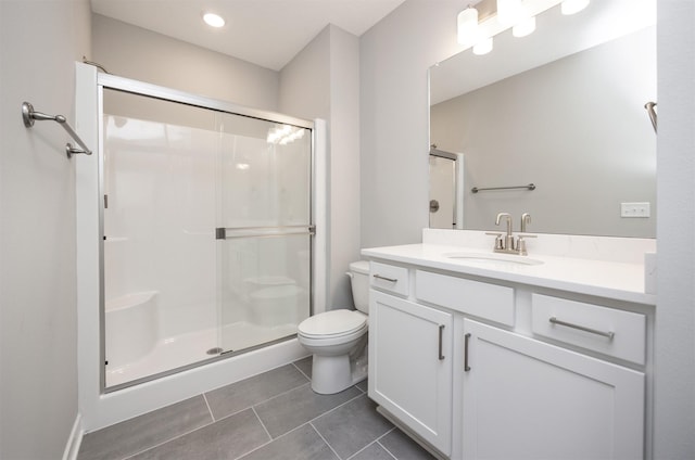 bathroom featuring walk in shower, vanity, tile patterned floors, and toilet