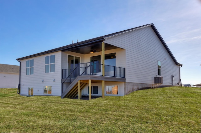 rear view of house with ceiling fan, central air condition unit, and a lawn