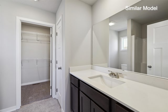 bathroom featuring vanity, a shower, and toilet