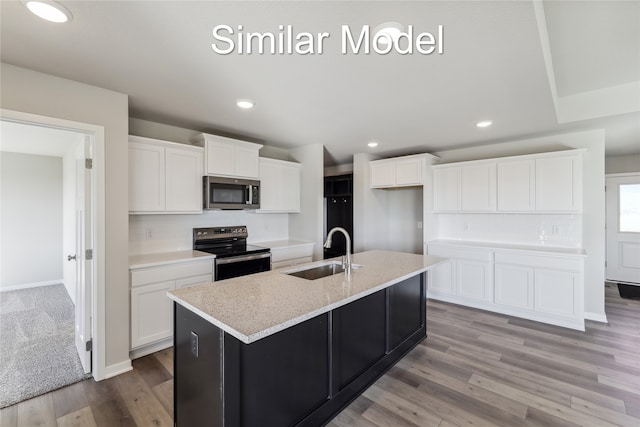 kitchen featuring sink, white cabinetry, electric range, a center island with sink, and decorative backsplash