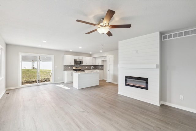 unfurnished living room featuring recessed lighting, visible vents, a ceiling fan, and a large fireplace