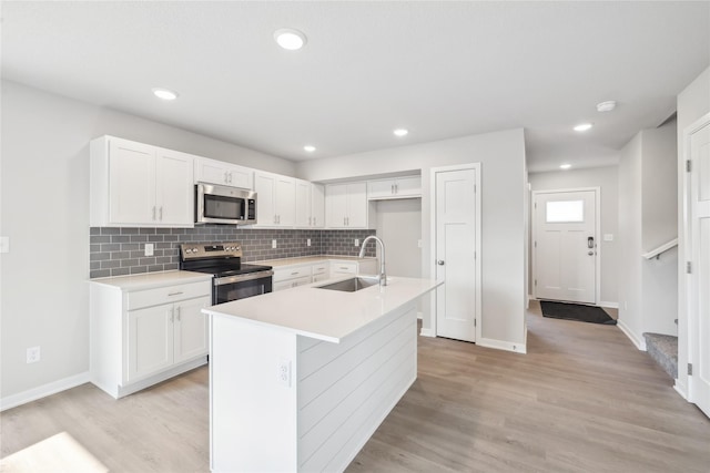 kitchen featuring appliances with stainless steel finishes, a sink, and white cabinetry