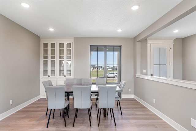 dining area featuring a textured ceiling and light wood-type flooring