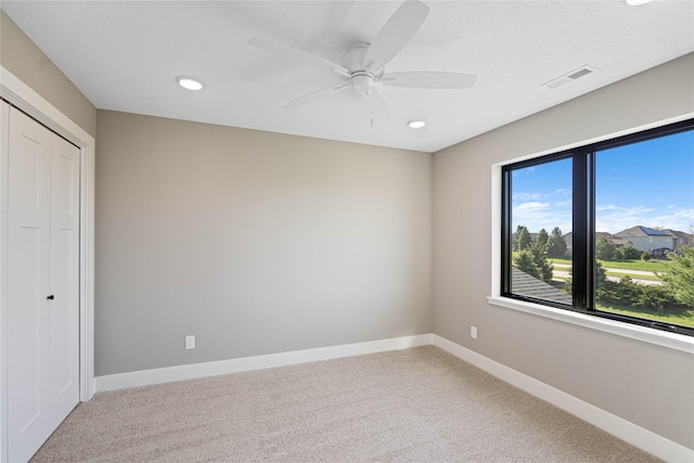 unfurnished bedroom featuring carpet floors, ceiling fan, and a closet