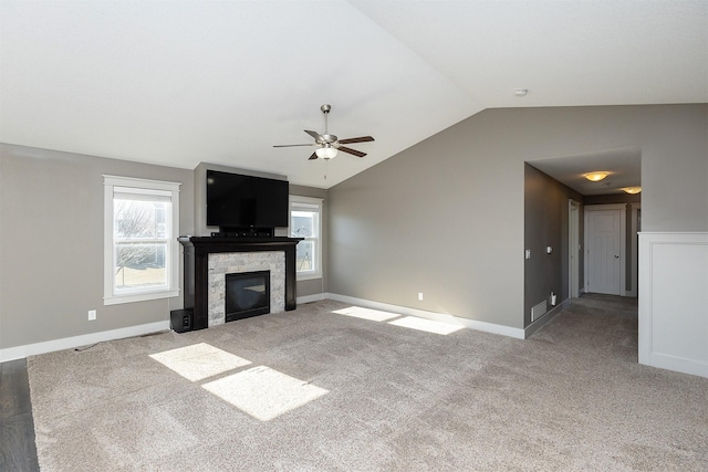 unfurnished living room with vaulted ceiling, light colored carpet, and ceiling fan