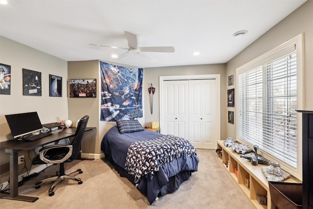 carpeted bedroom featuring ceiling fan and a closet