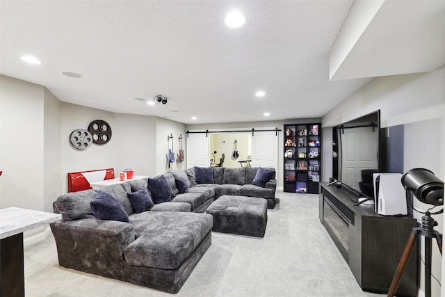 carpeted living room featuring a barn door and a textured ceiling