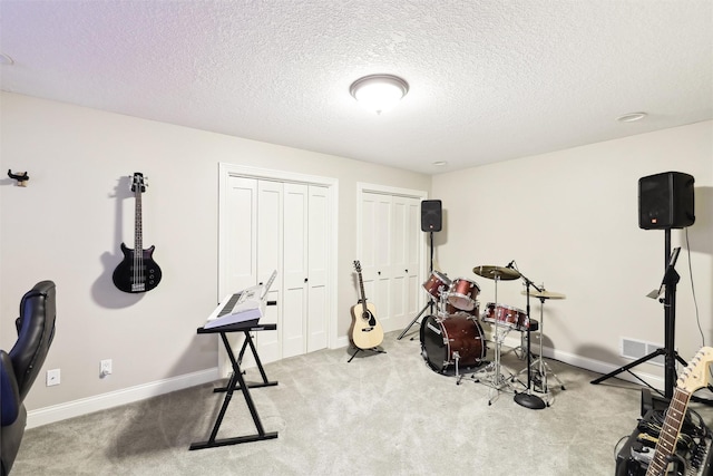 exercise area featuring carpet flooring and a textured ceiling