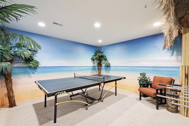 recreation room with a water view, carpet floors, and a beach view