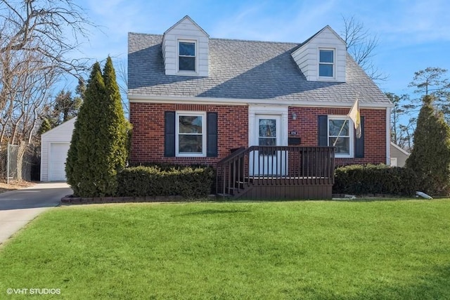 cape cod-style house with a garage, an outbuilding, and a front lawn