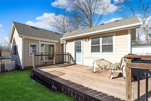 back of property featuring a wooden deck and a yard