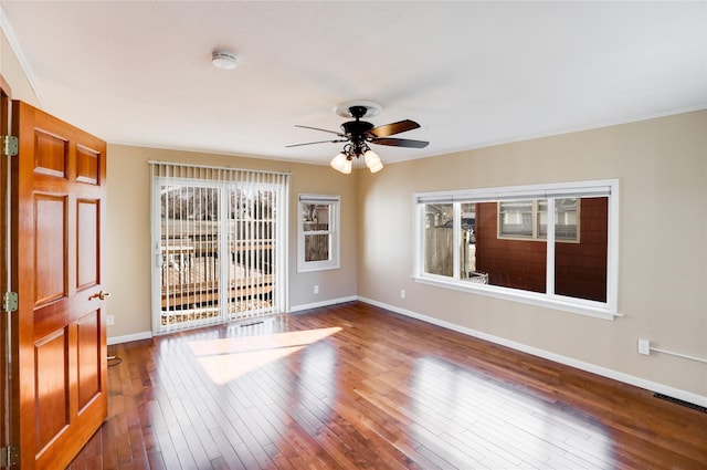 spare room featuring plenty of natural light, dark hardwood / wood-style floors, and ceiling fan