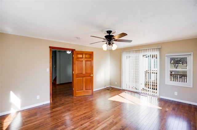 spare room with ornamental molding, dark wood-type flooring, and ceiling fan