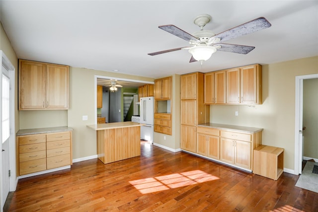 kitchen featuring ceiling fan, dark hardwood / wood-style floors, white fridge, and light brown cabinets