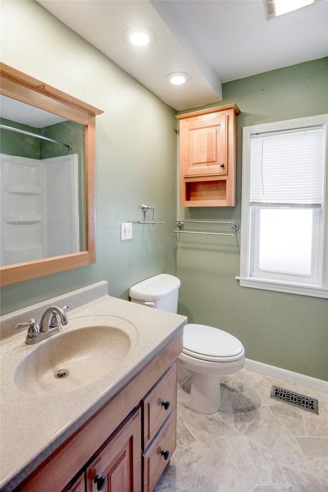 bathroom with vanity, toilet, and a shower