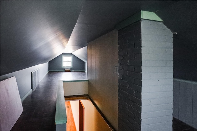 additional living space featuring lofted ceiling and dark wood-type flooring