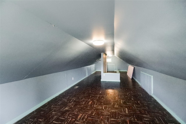 bonus room featuring dark parquet flooring and lofted ceiling