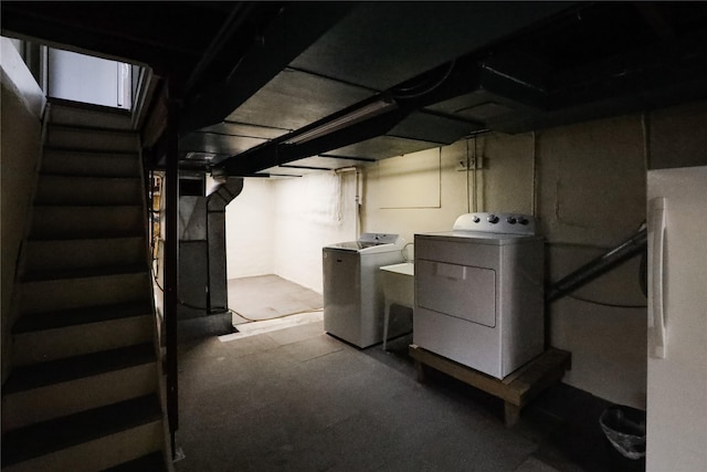 basement with white refrigerator, independent washer and dryer, and refrigerator