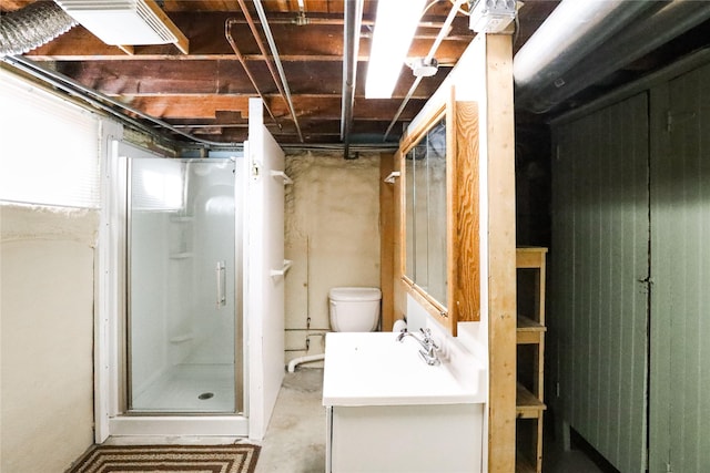 bathroom with an enclosed shower, vanity, concrete flooring, and toilet