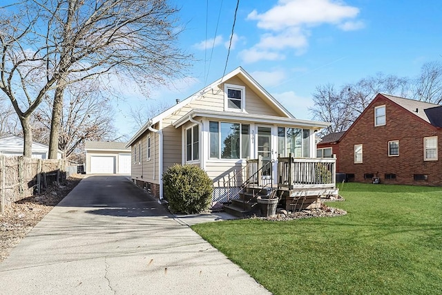 bungalow-style home with a garage, an outdoor structure, a sunroom, and a front lawn