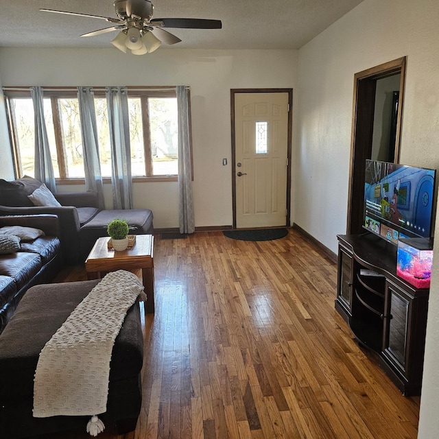 living room with ceiling fan, hardwood / wood-style floors, and a textured ceiling