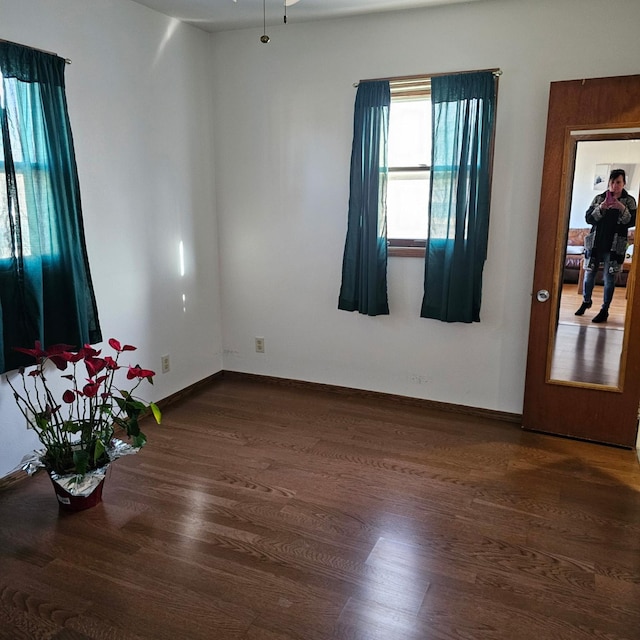 unfurnished room with dark wood-type flooring