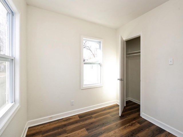 unfurnished bedroom featuring dark hardwood / wood-style flooring and a closet