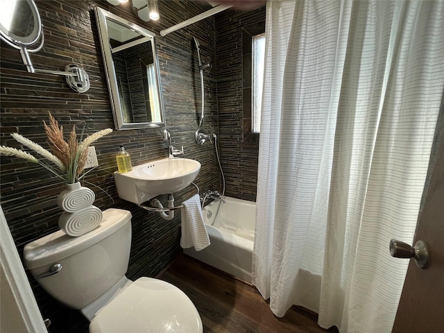 full bathroom with toilet, sink, wood-type flooring, shower / tub combo, and tile walls