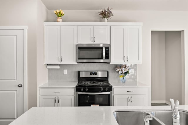 kitchen featuring white cabinetry, appliances with stainless steel finishes, and backsplash