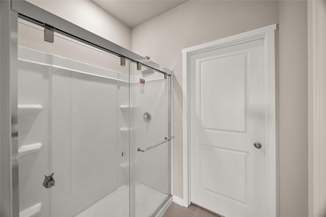 bathroom featuring a shower with door